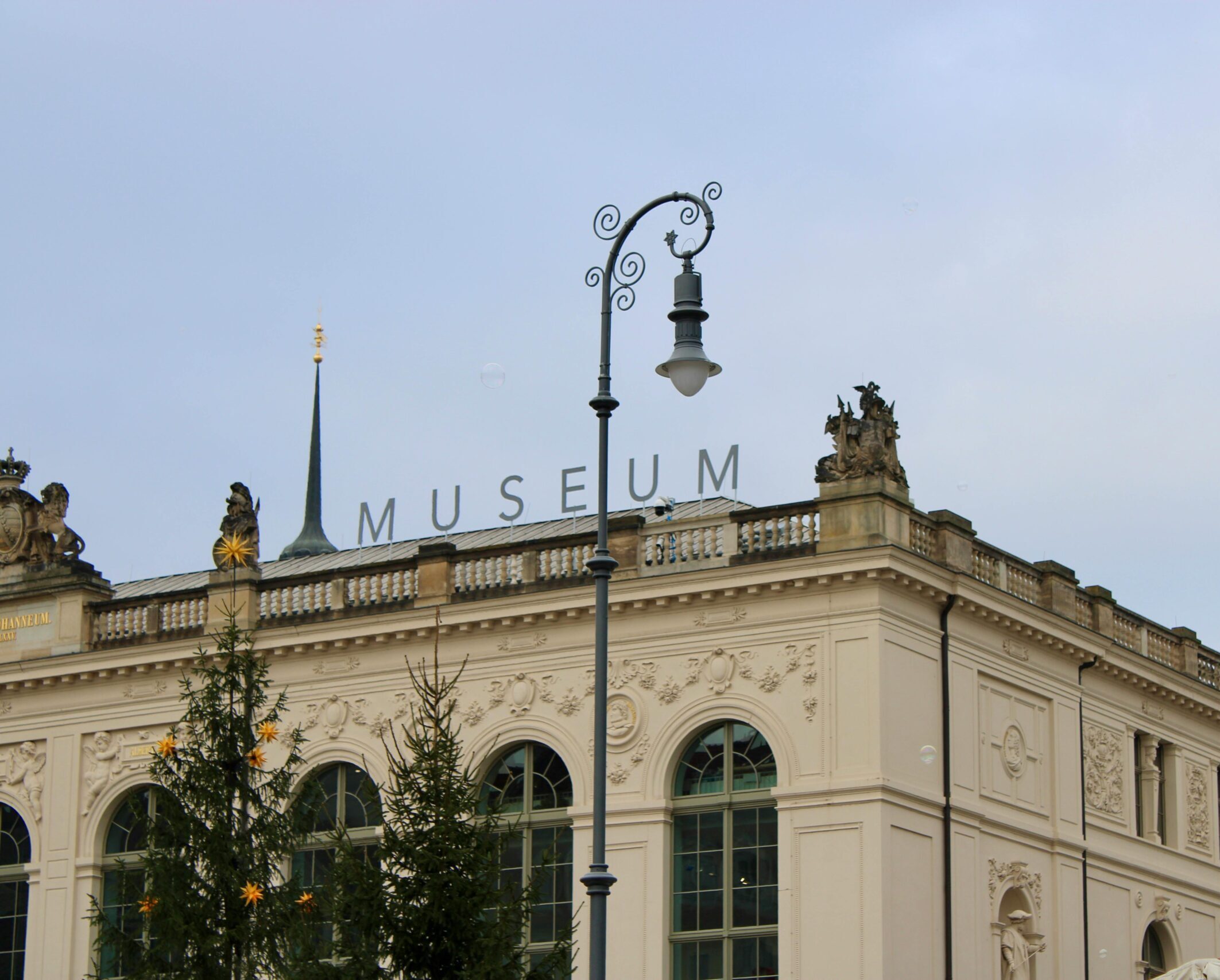 Classic museum exterior featuring ornate architectural elements under a cloudy sky.